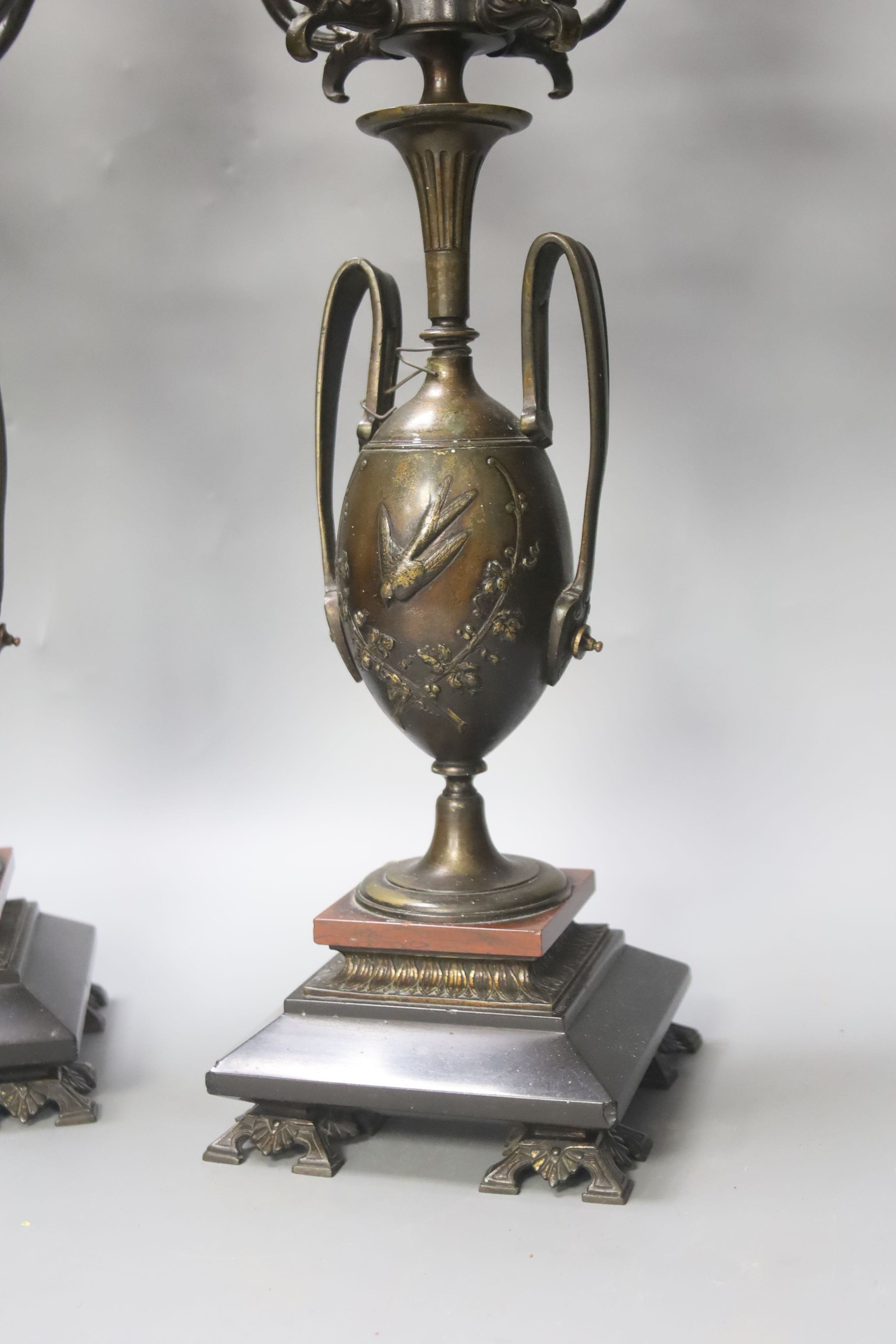 A pair of Aesthetic period bronze five light candelabra with twin handled vase supports on black and rouge marble base, height 48cm